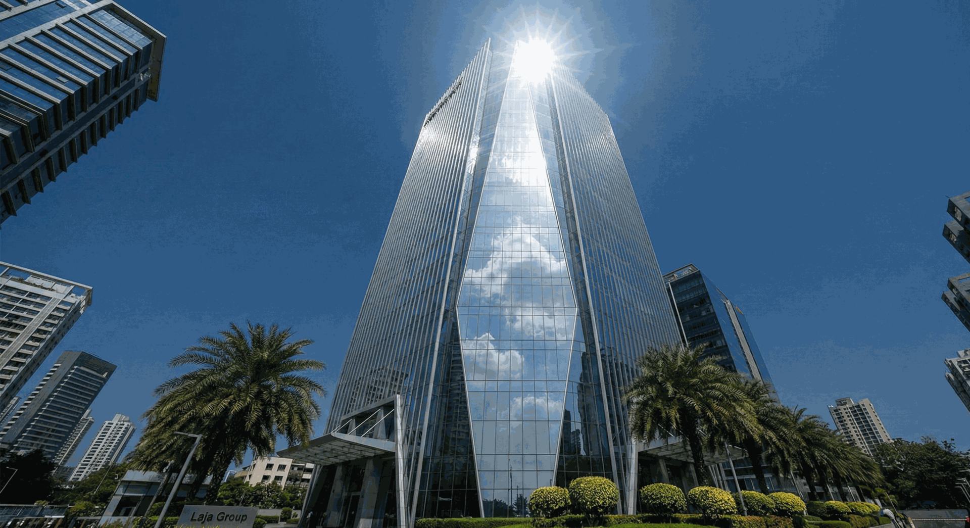 "Exterior view of the modern Laja Group corporate headquarters skyscraper in Mumbai's financial district, showing the Laja Group signage at the entrance."
